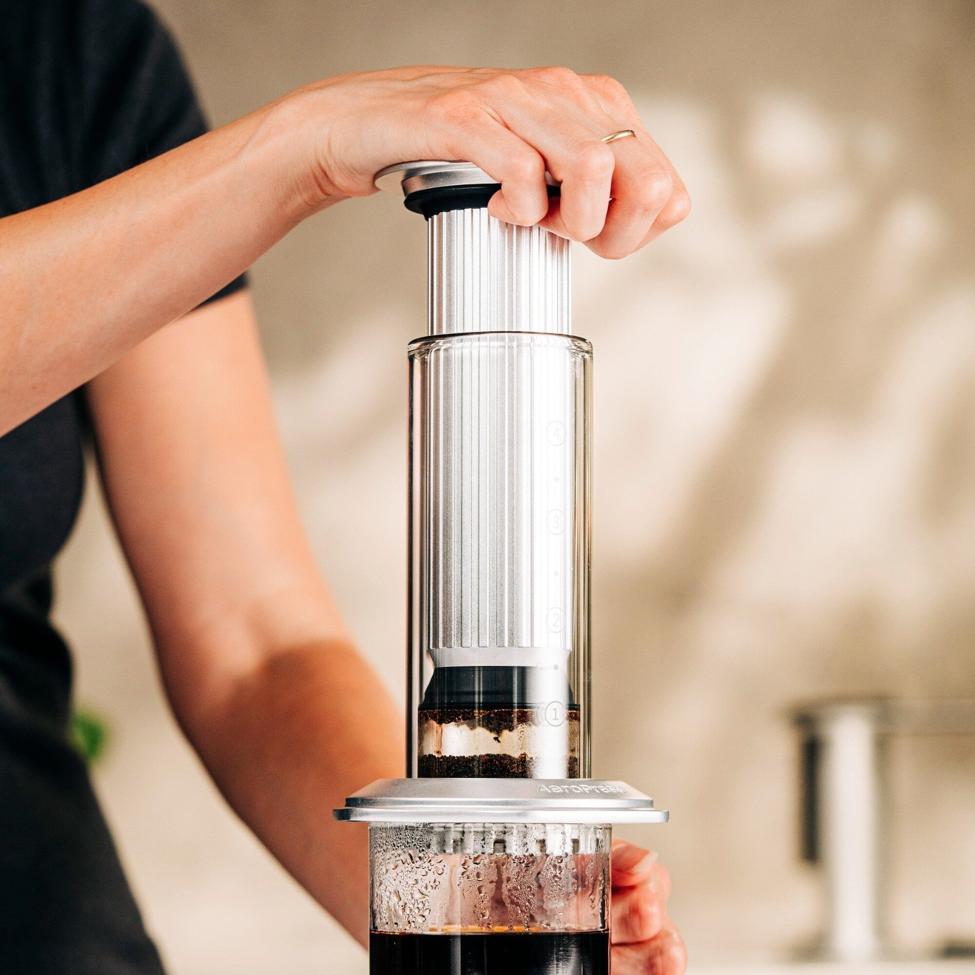 Person using an AeroPress Premium
